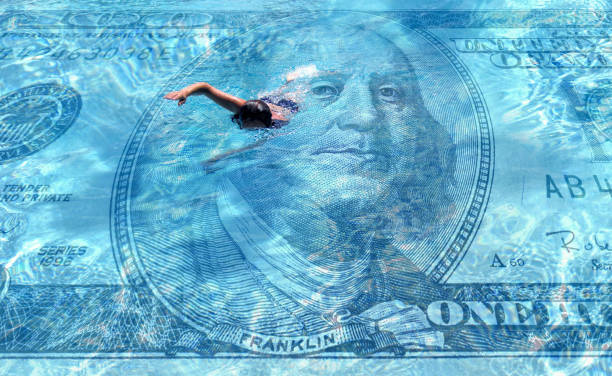 conceptual one person swimming on clear blue water covered with American one hundred dollar